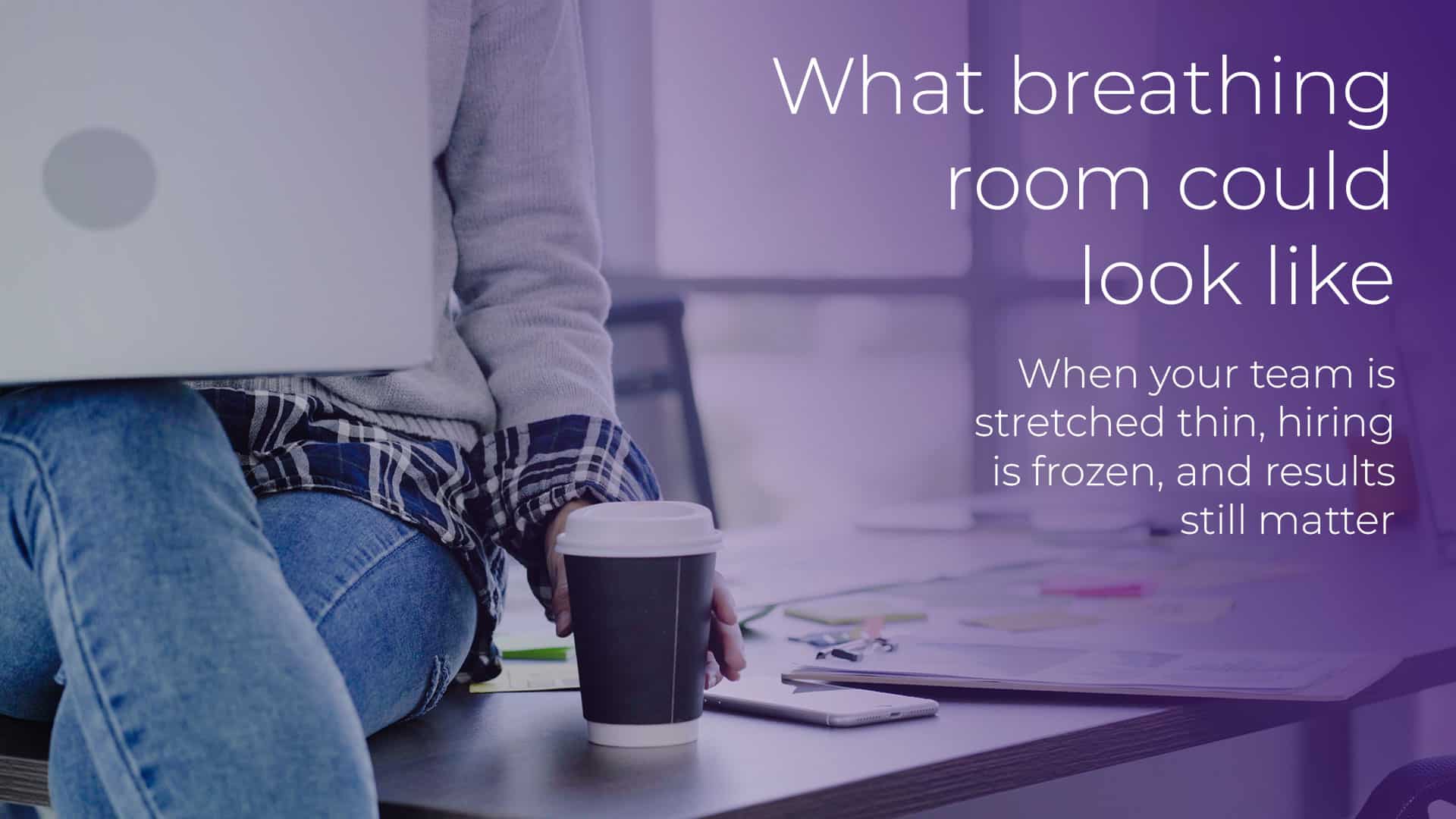 What breathing room could look like hero image shows a woman sitting on the corner of a desk, with her laptop on her knee, and reaching for a coffee