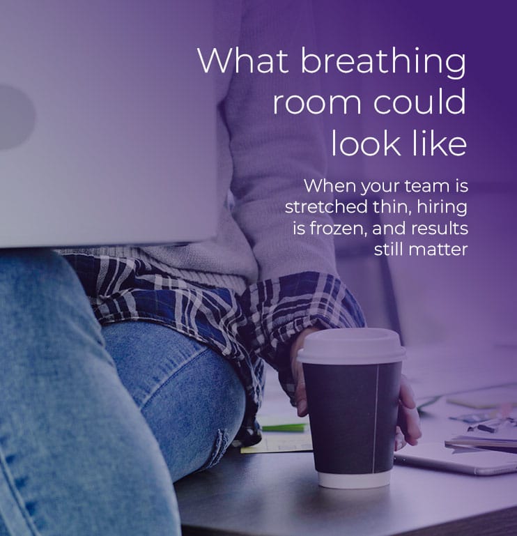 What breathing room could look like hero image shows a woman sitting on the corner of a desk, with her laptop on her knee, and reaching for a coffee